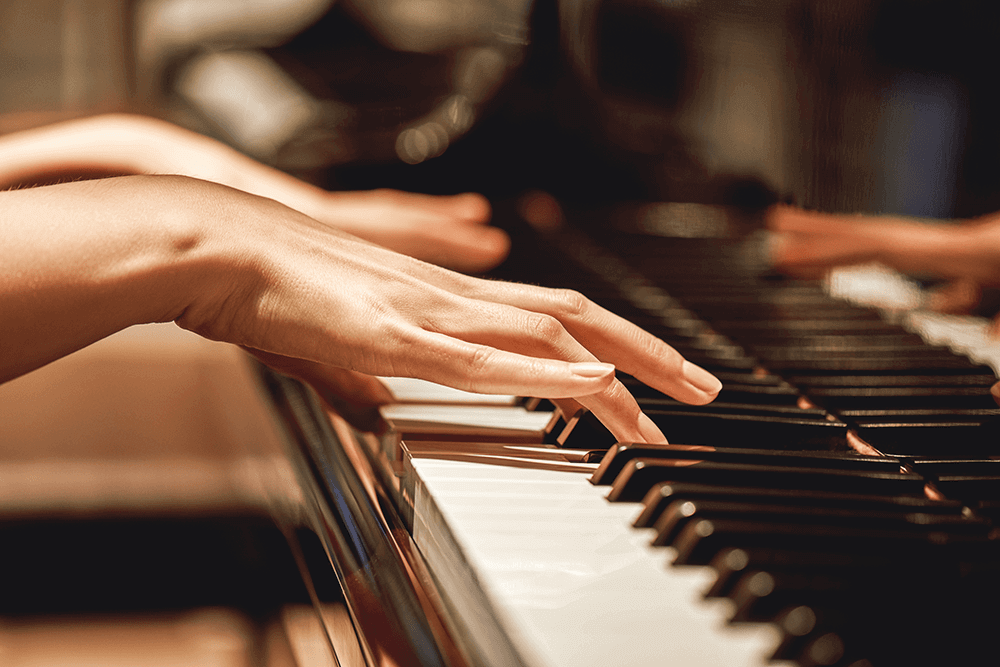 Two hands on the keyboard of a piano